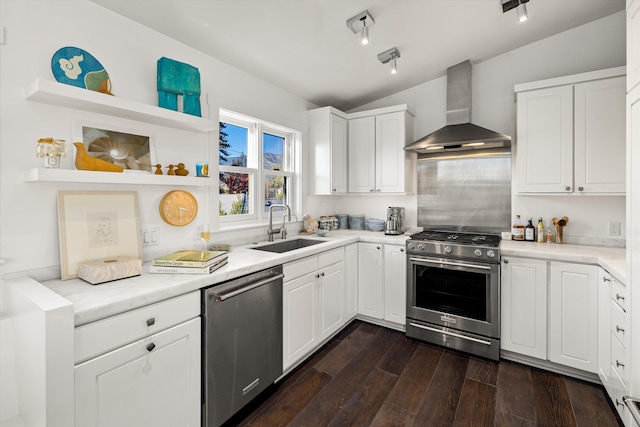 kitchen with stainless steel appliances, vaulted ceiling, dark wood-type flooring, sink, and wall chimney range hood