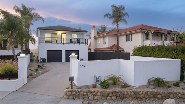 view of front of property with a balcony, a garage, and cooling unit