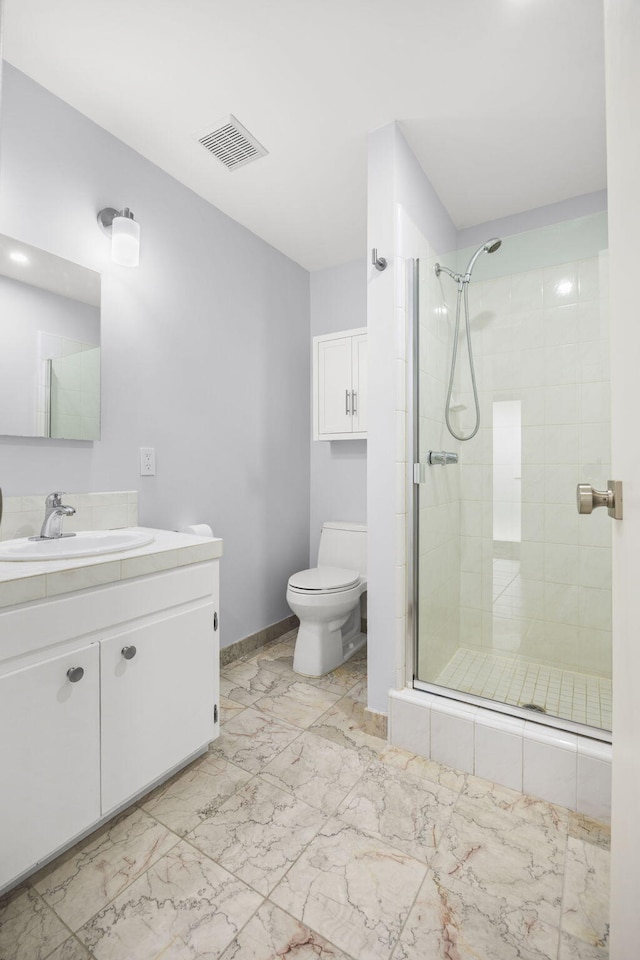 bathroom featuring toilet, an enclosed shower, and vanity