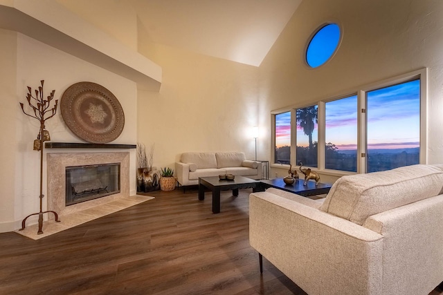 living room with a high end fireplace, dark hardwood / wood-style floors, and high vaulted ceiling