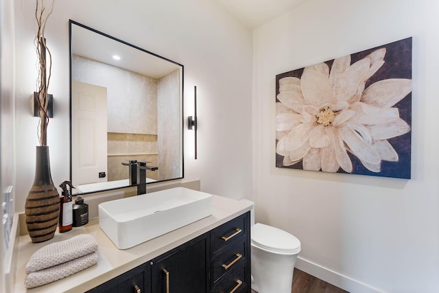 bathroom with hardwood / wood-style floors, vanity, and toilet