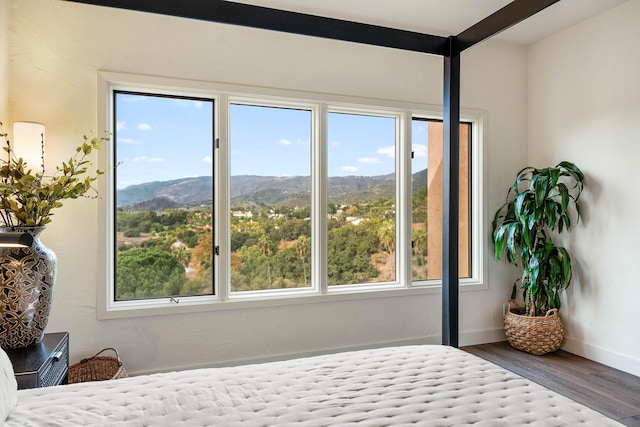 bedroom with hardwood / wood-style flooring and a mountain view