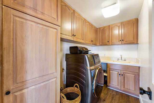 laundry area featuring cabinets, sink, dark wood-type flooring, and washing machine and clothes dryer