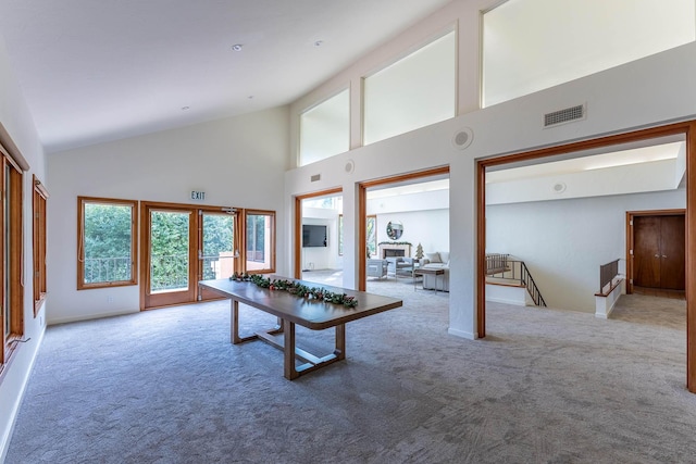 playroom with a fireplace, light carpet, french doors, and high vaulted ceiling