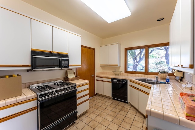 kitchen featuring black appliances, white cabinets, sink, and tile countertops