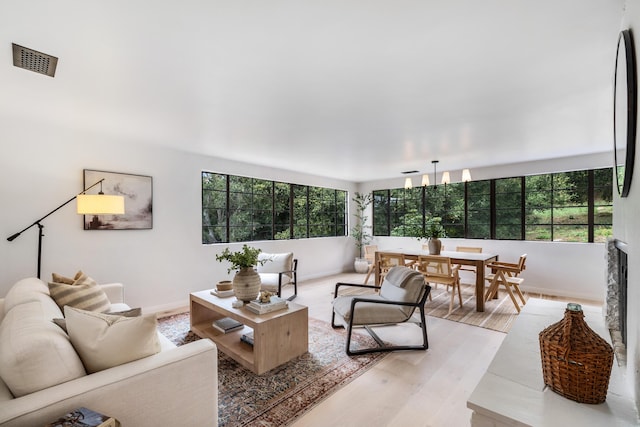 living room featuring a notable chandelier, plenty of natural light, and wood-type flooring