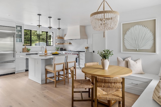 dining area featuring a chandelier, light hardwood / wood-style flooring, and sink