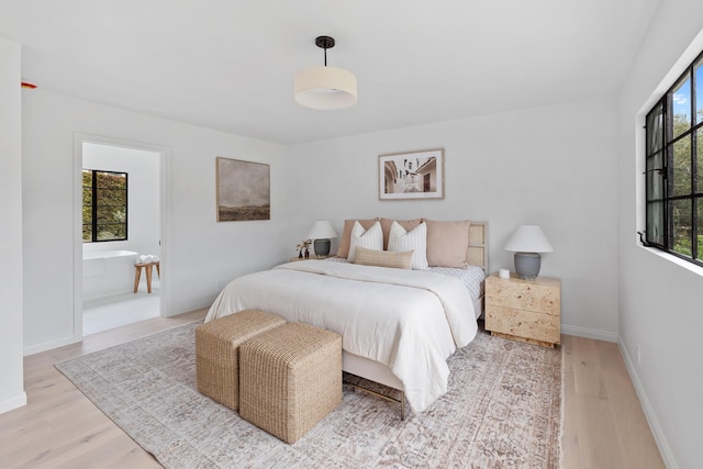 bedroom with light wood-type flooring and multiple windows