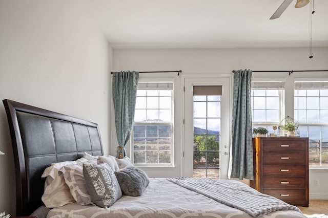 carpeted bedroom with ceiling fan, access to outside, and multiple windows