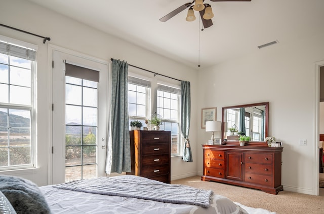 bedroom featuring ceiling fan, light colored carpet, access to outside, and multiple windows