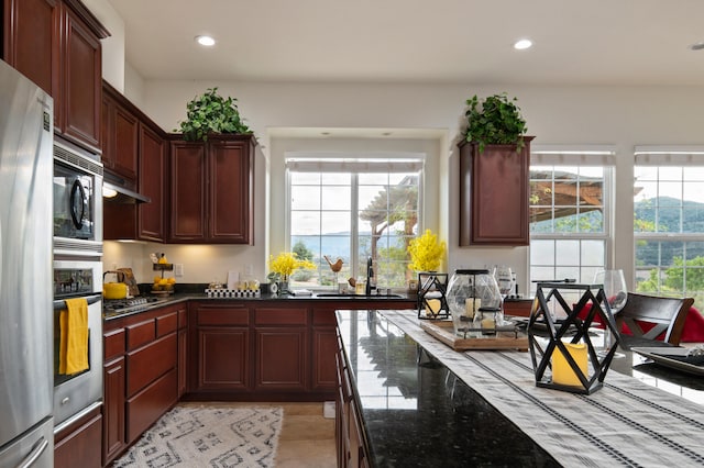 kitchen featuring dark stone countertops, sink, and appliances with stainless steel finishes