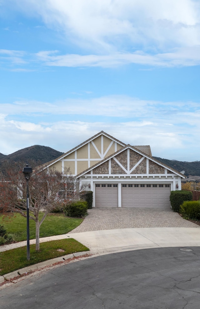 view of front of home featuring a mountain view, a garage, and a front lawn