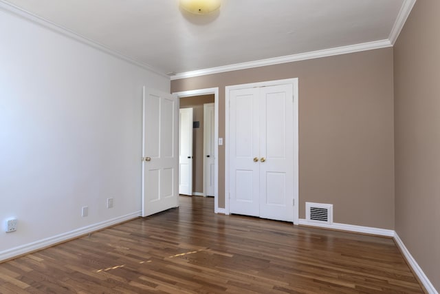 unfurnished bedroom with crown molding, a closet, and dark hardwood / wood-style floors