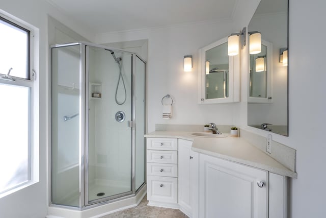 bathroom featuring tile patterned floors, vanity, a shower with shower door, and ornamental molding