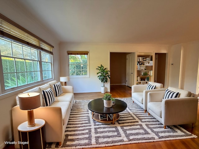 living room featuring wood-type flooring and built in shelves