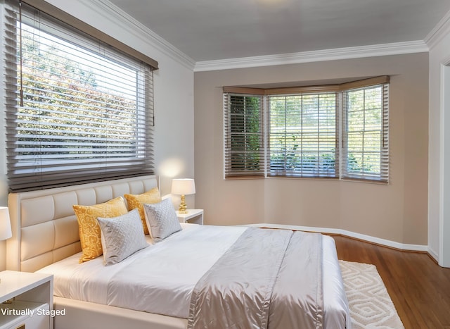 bedroom with wood-type flooring, multiple windows, and ornamental molding