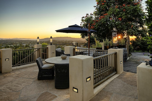 patio terrace at dusk featuring a mountain view