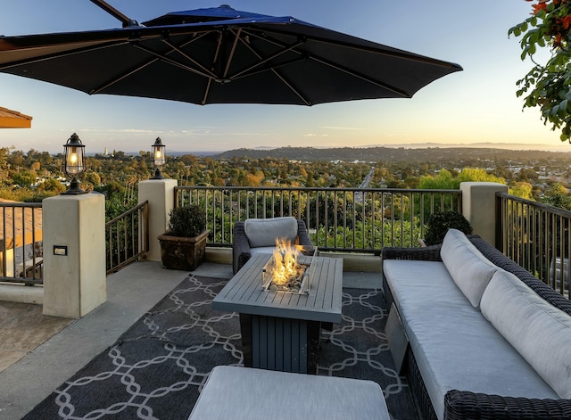 patio terrace at dusk featuring an outdoor living space with a fire pit