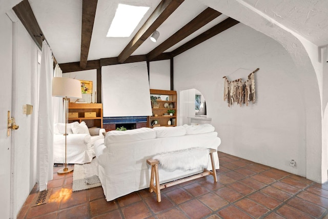 living room with beam ceiling and dark tile patterned floors