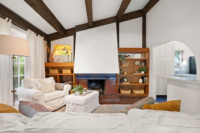 living room featuring lofted ceiling with beams and a fireplace