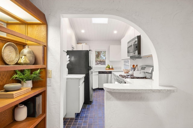 kitchen featuring white cabinets, stainless steel appliances, dark tile patterned flooring, and wood ceiling