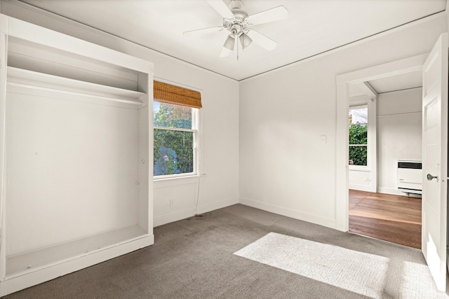 unfurnished room with carpet, heating unit, ceiling fan, and a healthy amount of sunlight