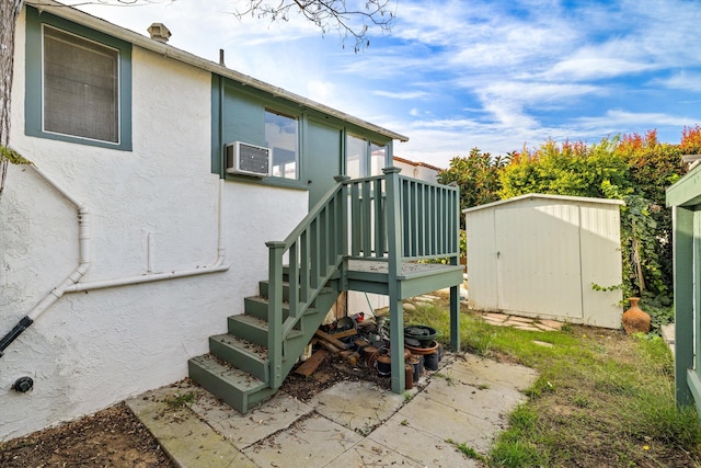 exterior space featuring a wall unit AC and a storage unit