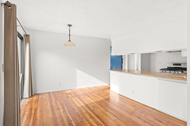 interior space with a textured ceiling and light hardwood / wood-style flooring