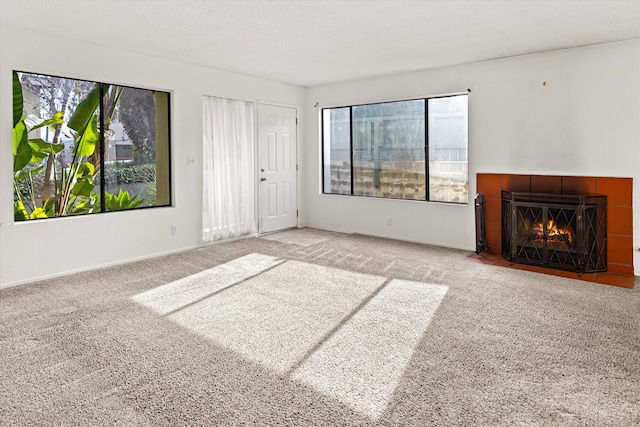 unfurnished living room featuring a fireplace, carpet floors, and a healthy amount of sunlight