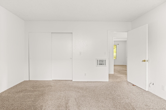 unfurnished bedroom with light carpet and a closet