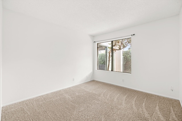 carpeted empty room featuring a textured ceiling