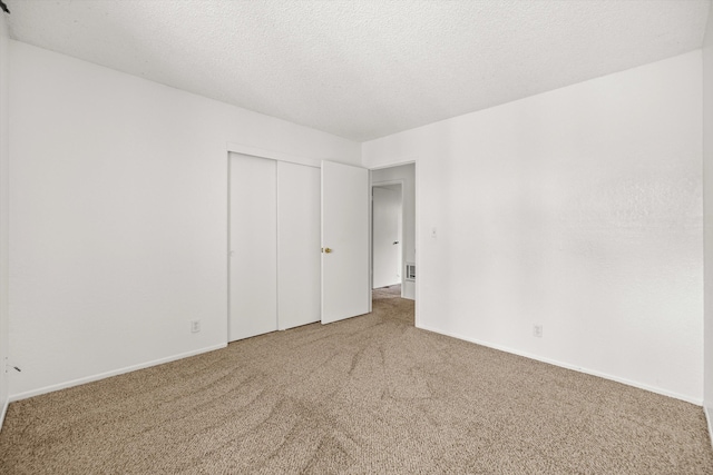 unfurnished bedroom featuring a closet, carpet floors, and a textured ceiling