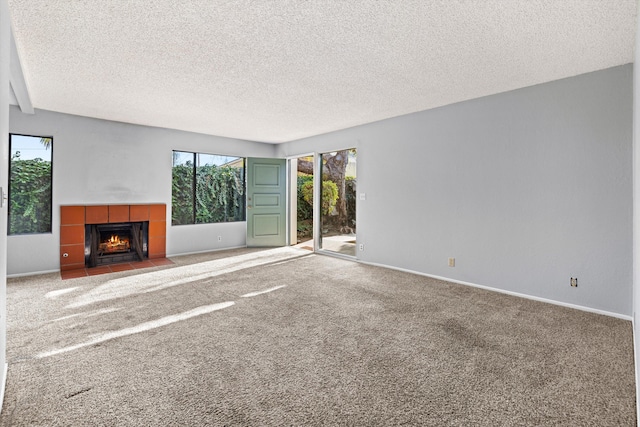 unfurnished living room with a fireplace, carpet floors, and a textured ceiling