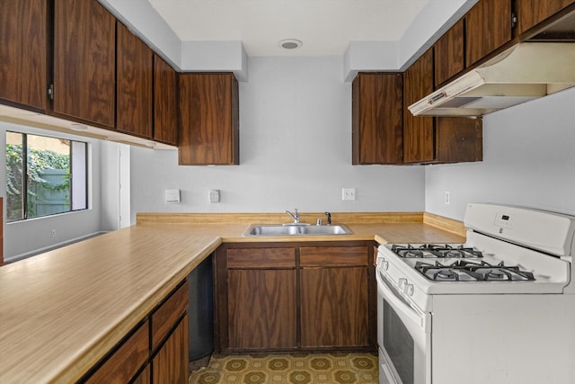 kitchen with dark brown cabinetry, white range with gas stovetop, and sink