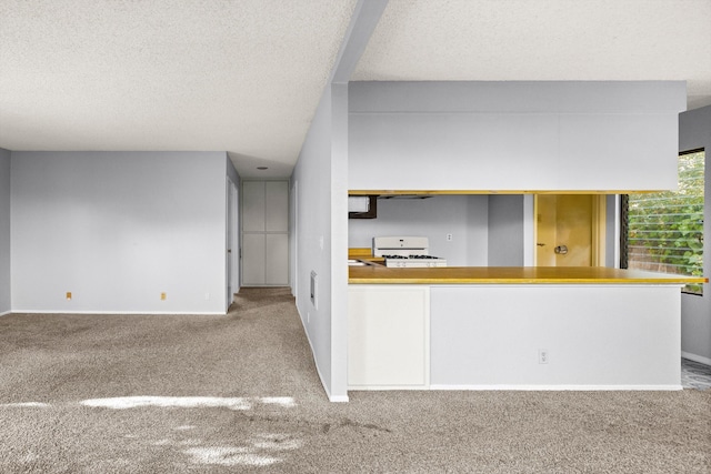 kitchen featuring carpet, a textured ceiling, and white gas range