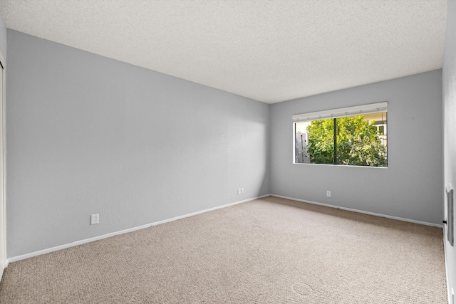 carpeted empty room with a textured ceiling