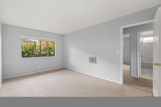 spare room featuring carpet flooring and a textured ceiling