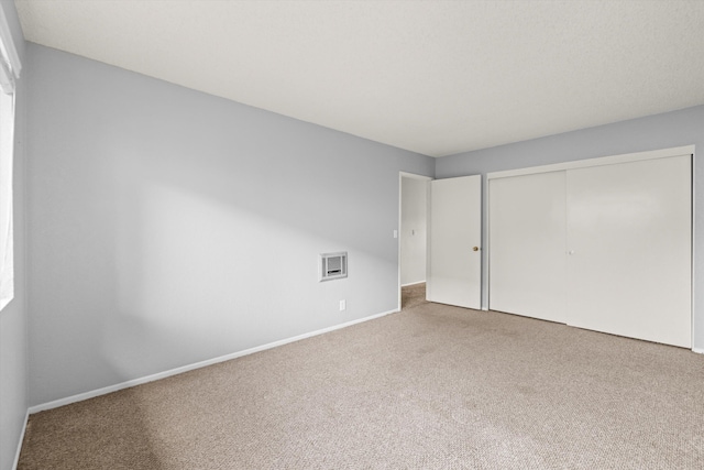 unfurnished bedroom with carpet flooring and a closet