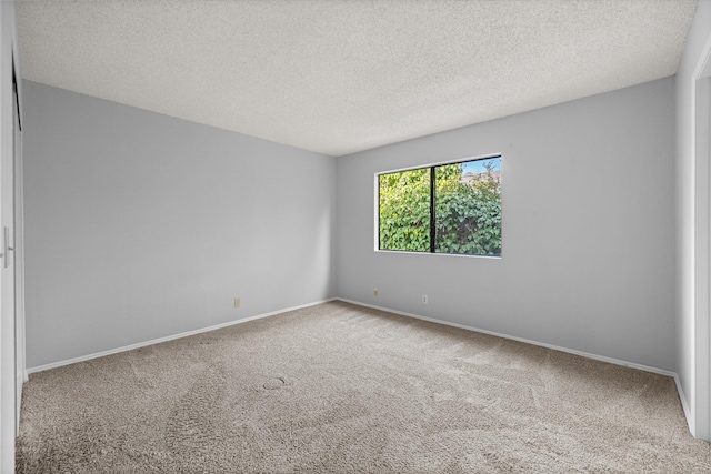 carpeted spare room featuring a textured ceiling