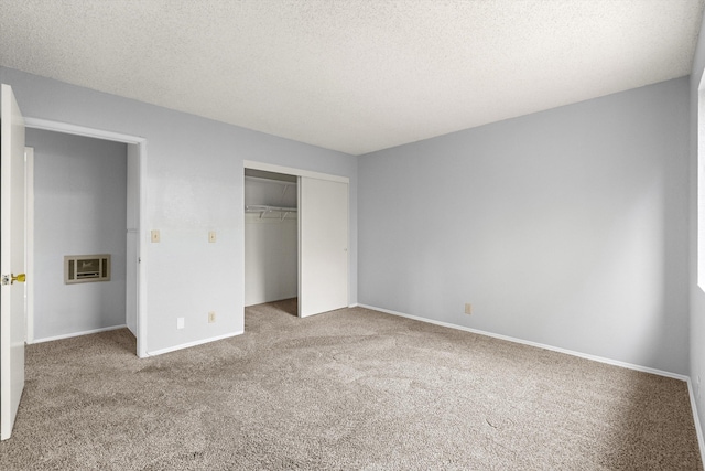 unfurnished bedroom with carpet flooring, a textured ceiling, and a closet