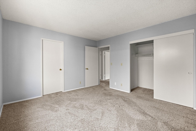 unfurnished bedroom with carpet, a textured ceiling, and a closet