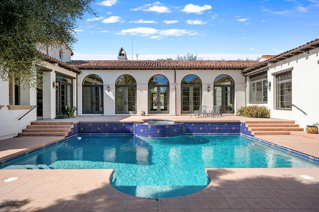 view of swimming pool featuring a patio area and an in ground hot tub