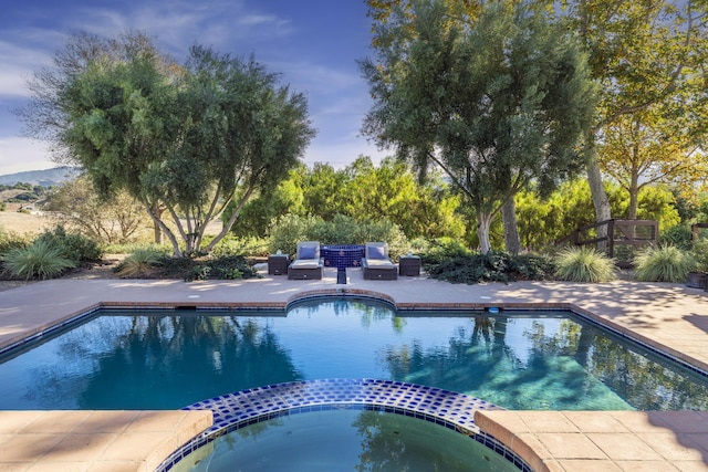 view of pool with an in ground hot tub and a patio area