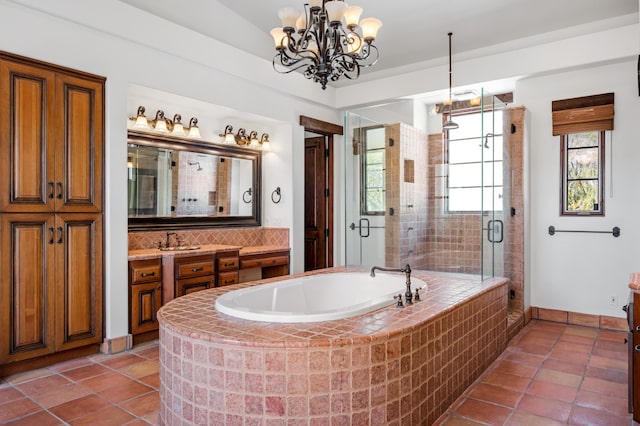 bathroom featuring tile patterned flooring, vanity, an inviting chandelier, and independent shower and bath