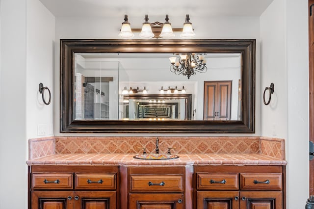 bathroom with backsplash, vanity, and an inviting chandelier