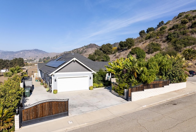 view of front of house featuring a mountain view, solar panels, and a garage