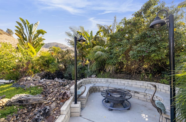 view of patio featuring a mountain view and an outdoor fire pit