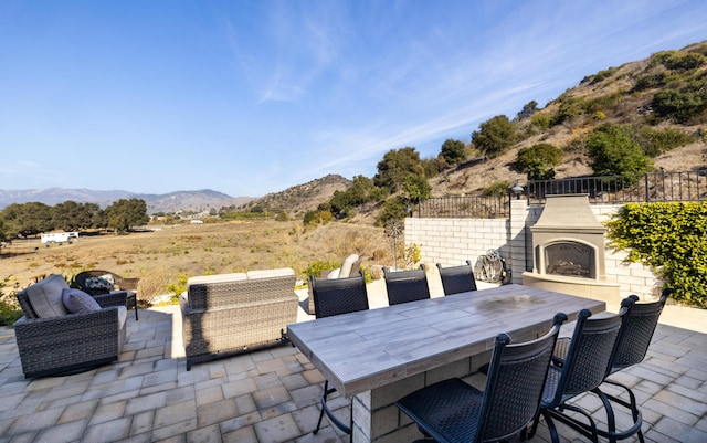 view of patio / terrace featuring a mountain view and an outdoor fireplace