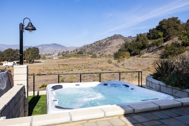 exterior space with a mountain view and a hot tub