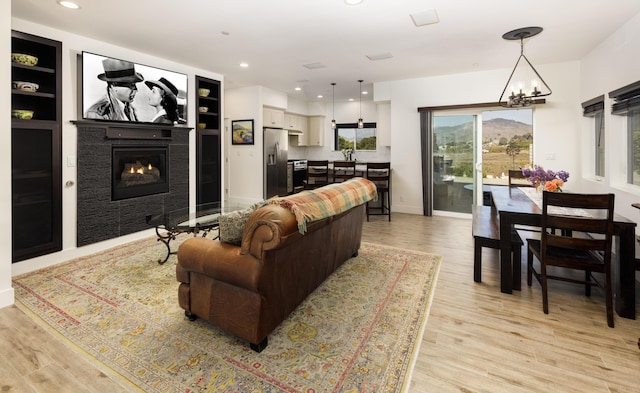 living room featuring a chandelier and light wood-type flooring